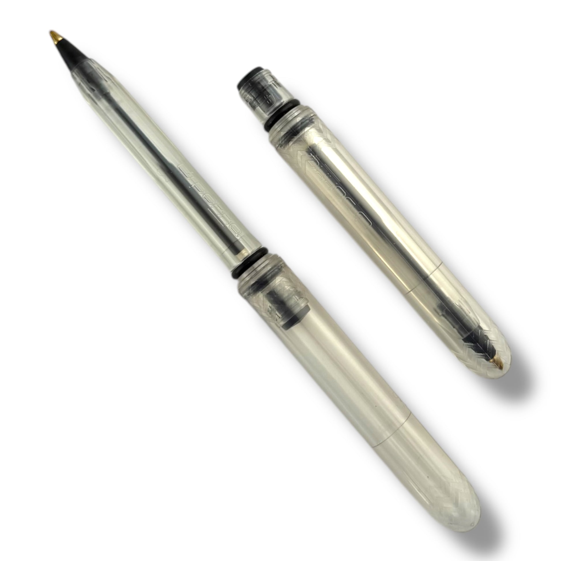 A transparent ballpoint pen with its cap removed, showing the black ink tip and the medium ballpoint nozzle.
