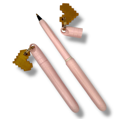 Pink pen with gold accents on a white background