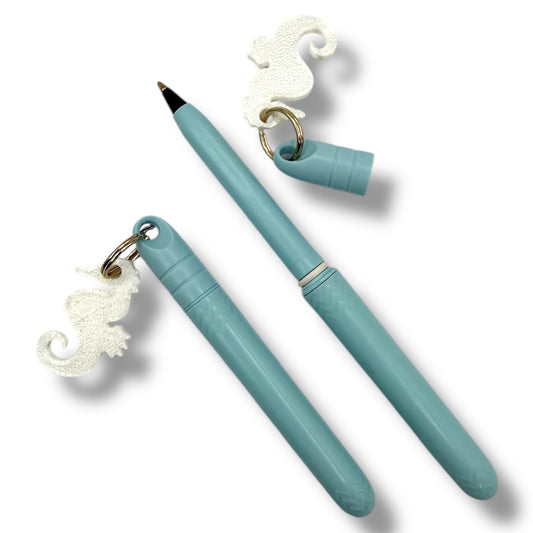 Turquoise pen with seahorse charm on a white background
