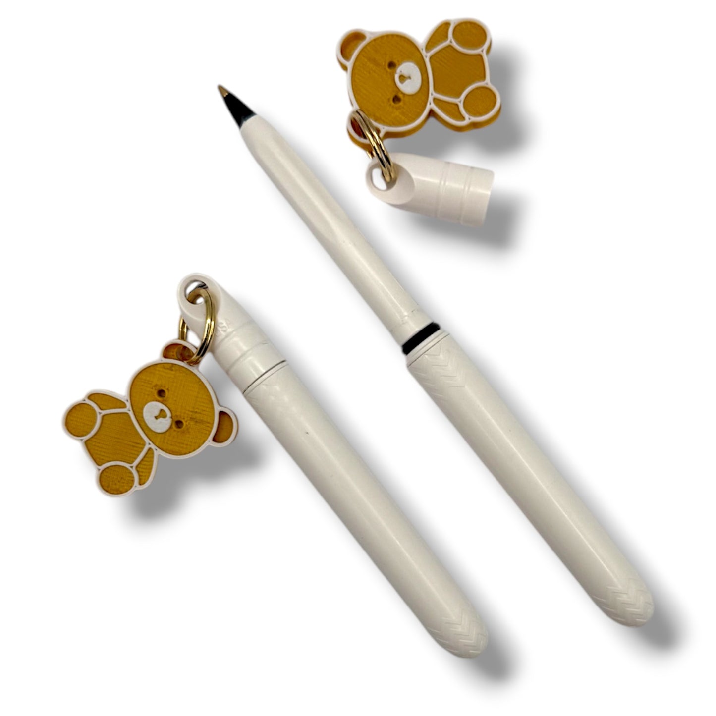 Two white pens with bear-shaped charms on a white background
