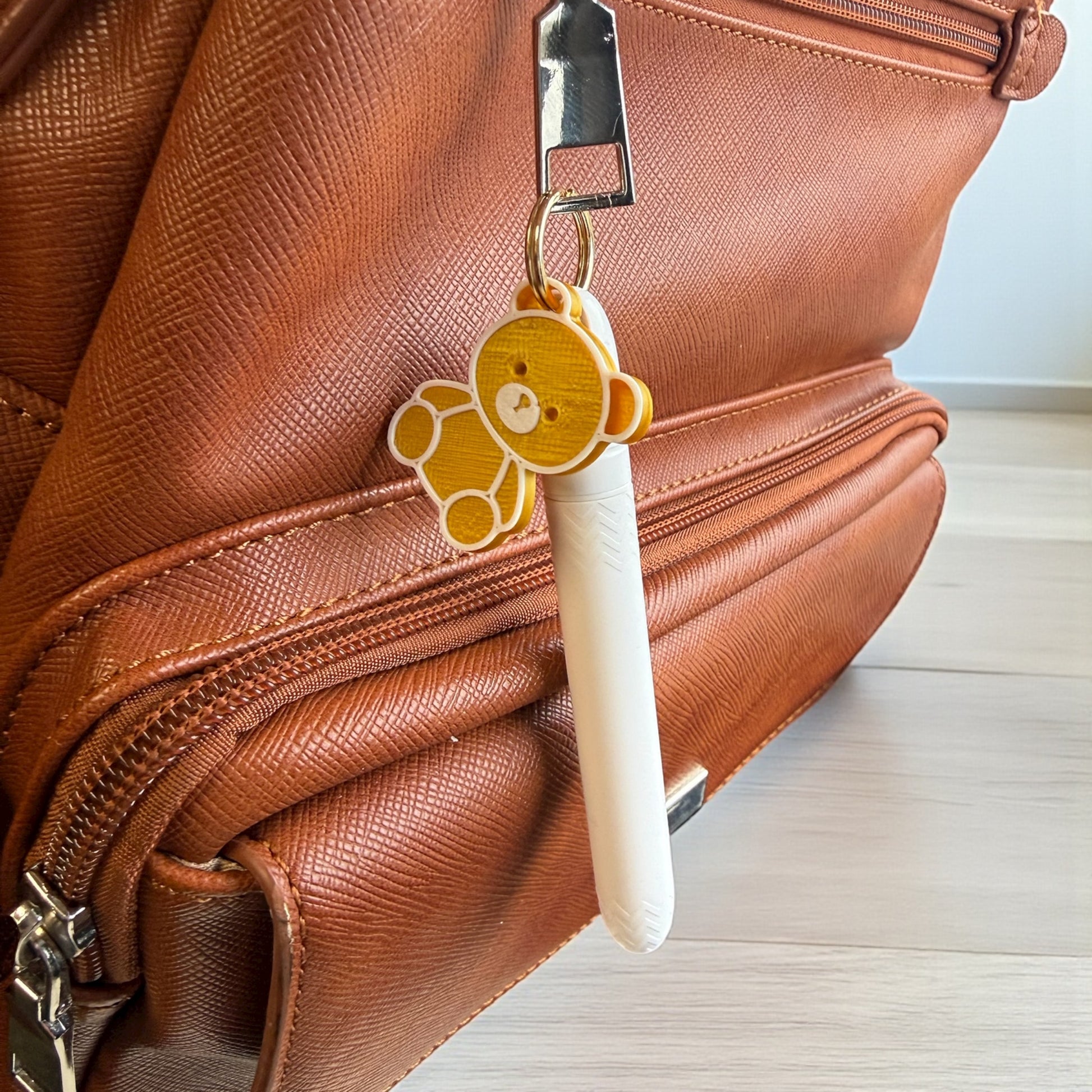 Brown leather bag with a teddy bear keychain attached