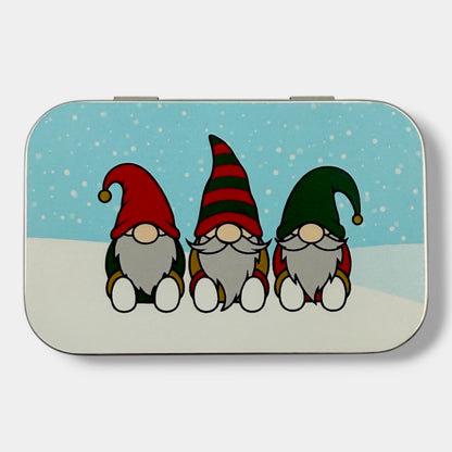 Rectangular tin with three cartoon gnomes on a snowy background