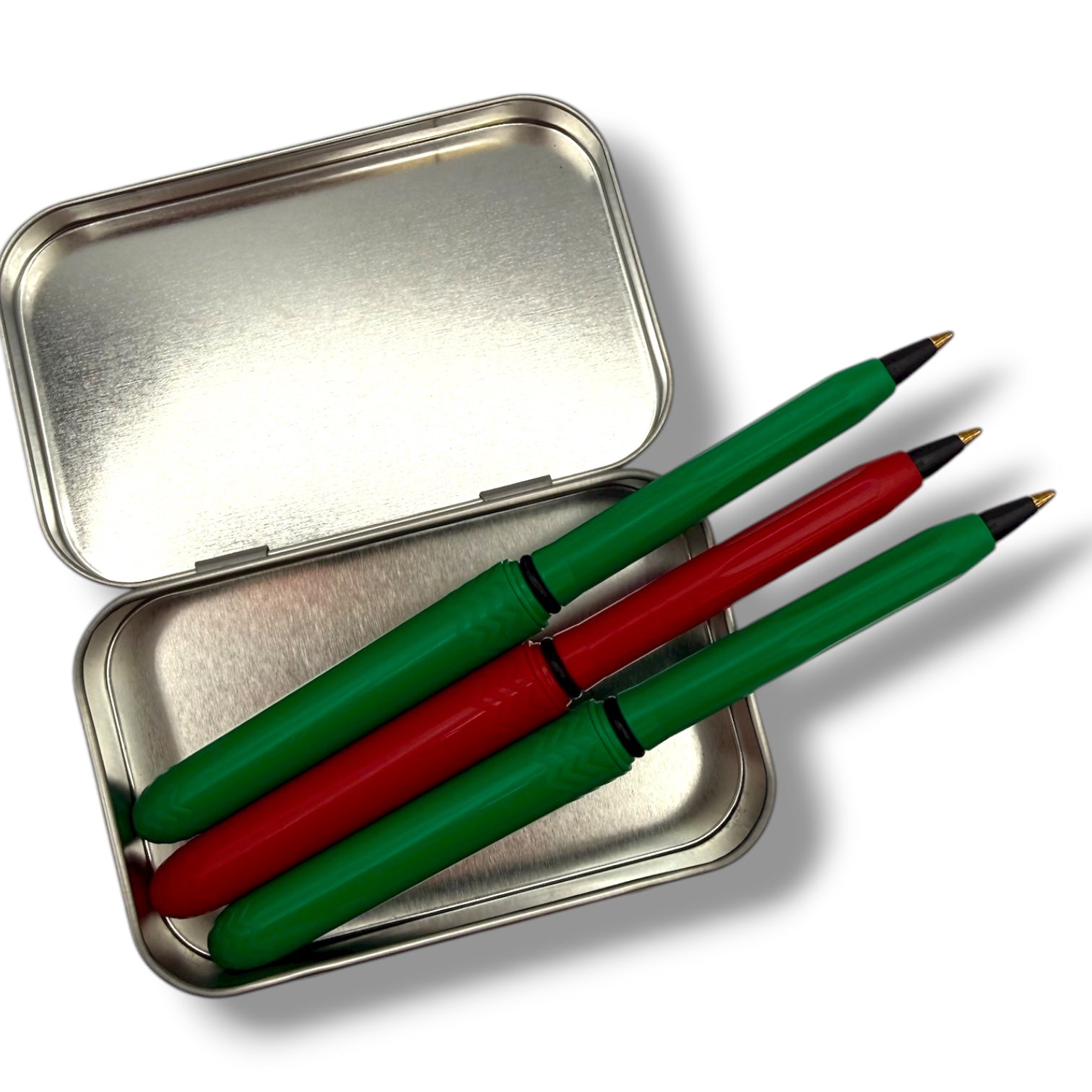 Three green and red pens in a metal case on a white background